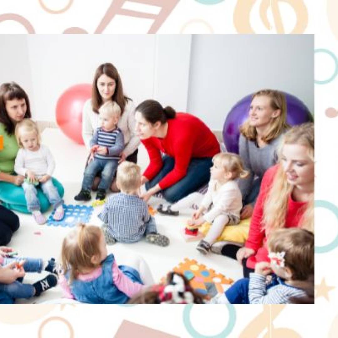 Young children and families participating in a Music Together class, playing instruments, singing, and engaging in group music activities.